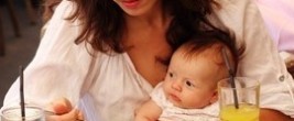 Mutter isst mit Baby auf dem Schoss