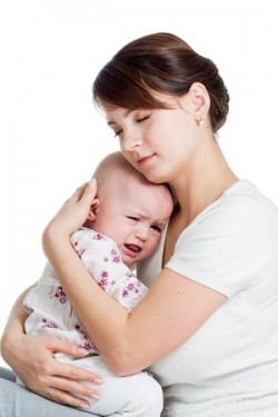 Mutter tröstet weinendes Baby