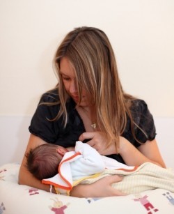 Mutter stillt ihr Baby in der Wiegenhaltung
