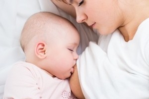 Mutter und Baby stillen nachts im Bett