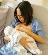 Mutter im Krankenhaus versucht ihr Baby zum Stillen anzulegen