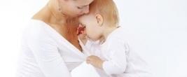 Kleinkind schaut der Mama neugierig in die Bluse