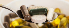 Tabletten und Pillen auf einem Löffel und in einer Schüssel