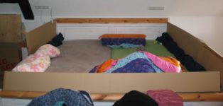Ehebett mit Möbelkartons als Gitter