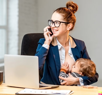 Mutter stillt vor dem Computer und mit Telefon in der Hand