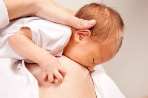 Baby an der Brust, Mund weit auf
