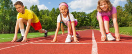 Drei kinder hocken in der Startposition zum Sprinten