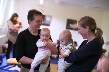 Foto einer Stillgruppe mit Müttern, die ihre Babys auf dem Arm halten und sich unterhalten