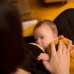 Eine Mutter stillt ihr Baby mit Down-Syndrom